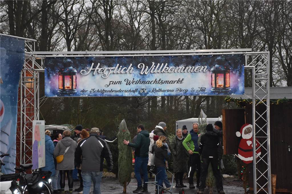 Menschen feiern auf dem Weihnachtsmarkt auf Hof Lenz in Ascheberg 2024.