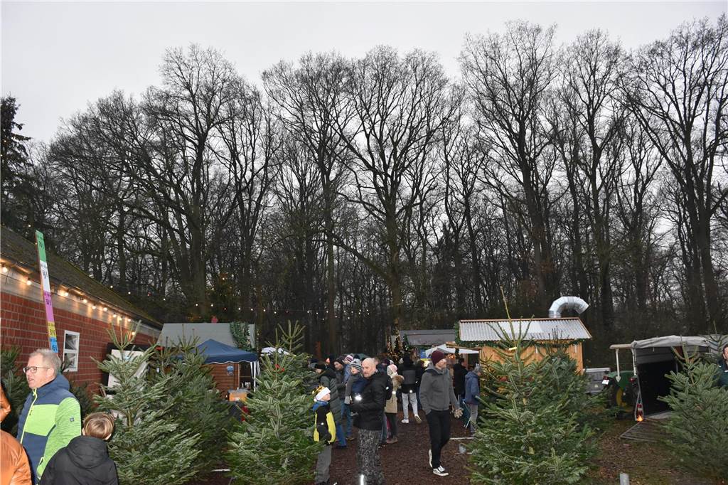 Menschen feiern auf dem Weihnachtsmarkt auf Hof Lenz in Ascheberg 2024.
