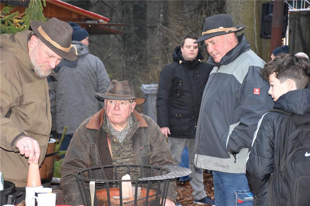 Menschen feiern auf dem Weihnachtsmarkt auf Hof Lenz in Ascheberg 2024.