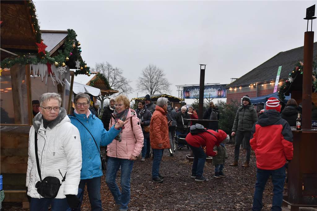 Menschen feiern auf dem Weihnachtsmarkt auf Hof Lenz in Ascheberg 2024.