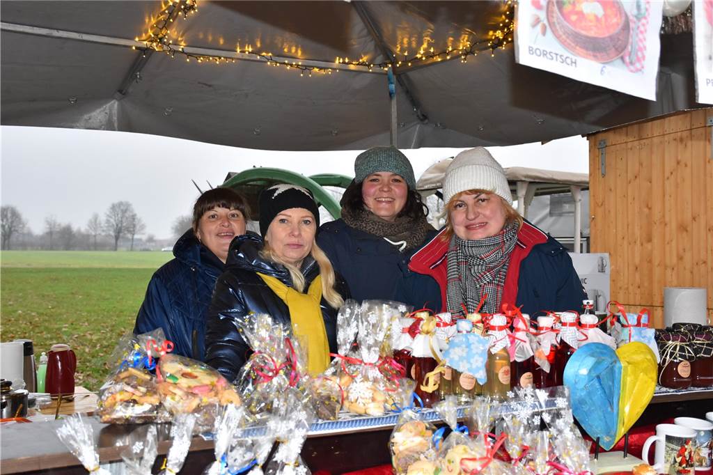 Menschen feiern auf dem Weihnachtsmarkt auf Hof Lenz in Ascheberg 2024.