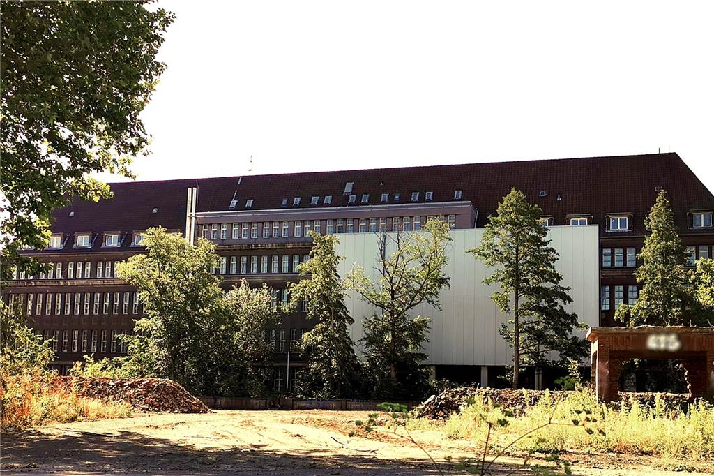So sieht das Gebäude auf der Rückseite aus. Die große metallfarbene Wand ist die Rückseite eines nachträglich angebauten Archivs.
