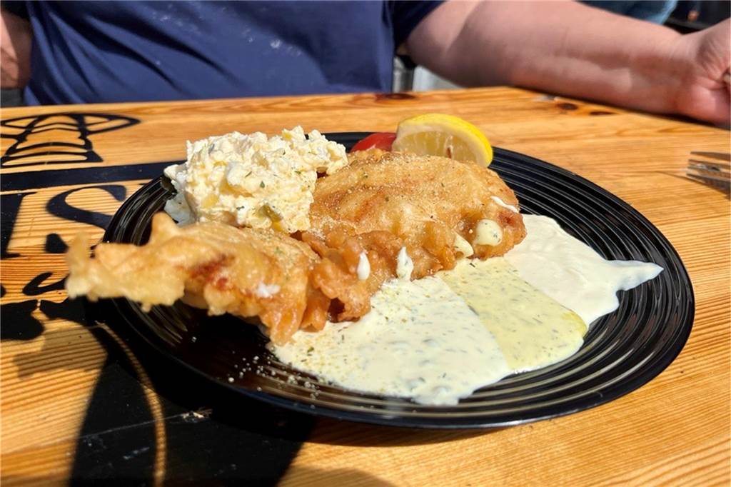 Ein Teller mit Backfisch vom Meisfeld-Fischstand steht beim Dortmunder Markt auf einem Tisch.