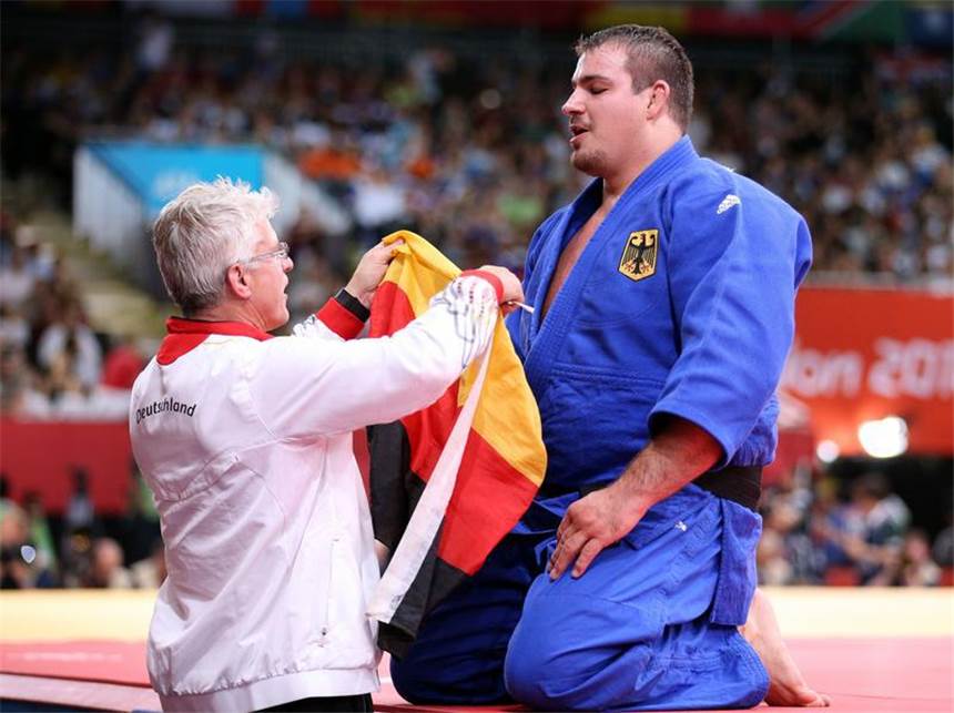 145-Kilo-Koloss Tölzer am Ziel - Endlich Judo-Medaille Sofort wird er von Trainer Detlef Ultsch mit einer deutschen Fahne ausgerüstet. Foto: Friso Gentsch