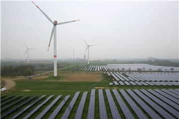 Solaranlage und Windräder: Die Stromproduktion aus erneuerbaren Energien ist in Deutschland auf einen neuen Höchststand geklettert. Foto: Christian Charisius/Illustration