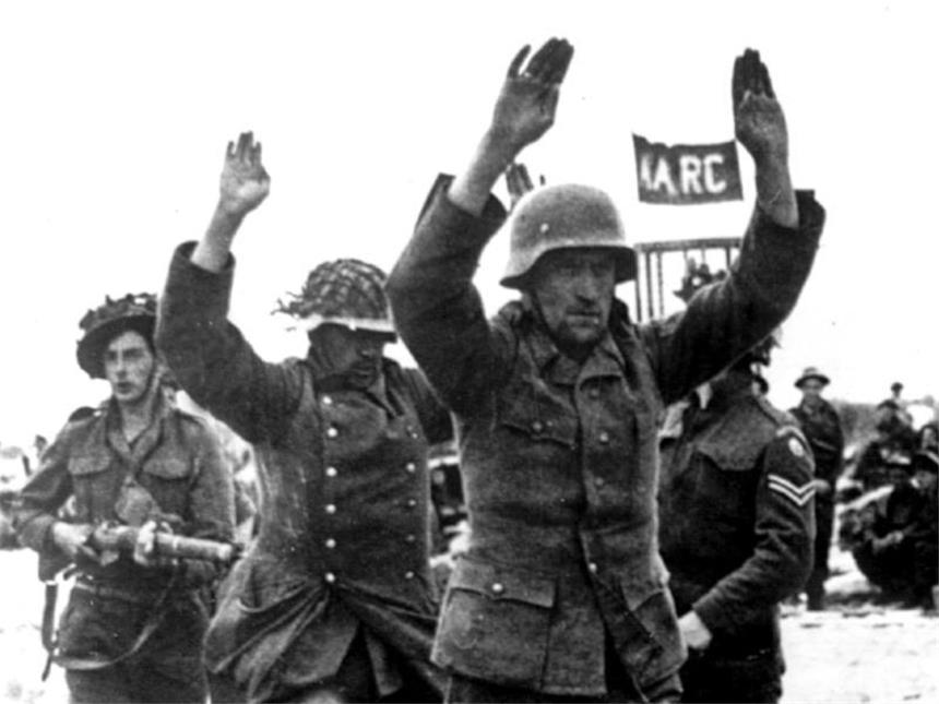 70 Jahre Kriegsende: «Sieg eines Ideals über eine Ideologie» Soldaten der alliierten Truppen führen zwei der ersten deutschen Kriegsgefangenen nach der Landung an der Küste ab. Am 6. Juni 1944 landeten die Alliierten an der Küste der Normandie. Foto: UPI/dpa
