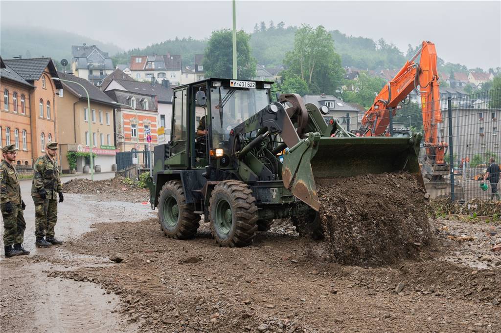 Unwetter in NRW: Mindestens 43 Todesopfer - mehrere Plünderungsversuche gemeldet – Liveblog Soldaten der Bundeswehr beseitigen mit einem Radlader die schweren Unwetterschäden in Hagen.