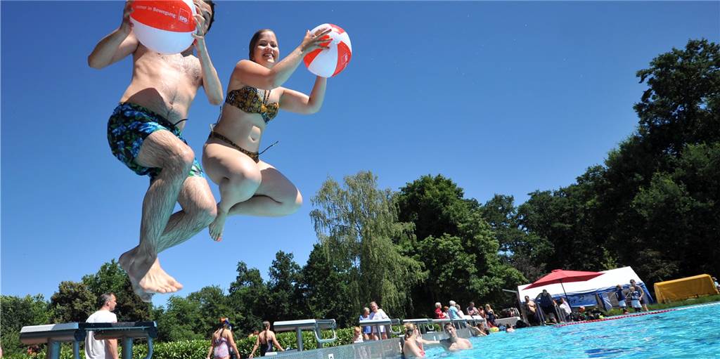 Nach Randale in Bochumer Freibad: Parkbad Nord hat kurzen Draht zur Polizei Zwei Menschen springen mit Bällen ins Wasser.