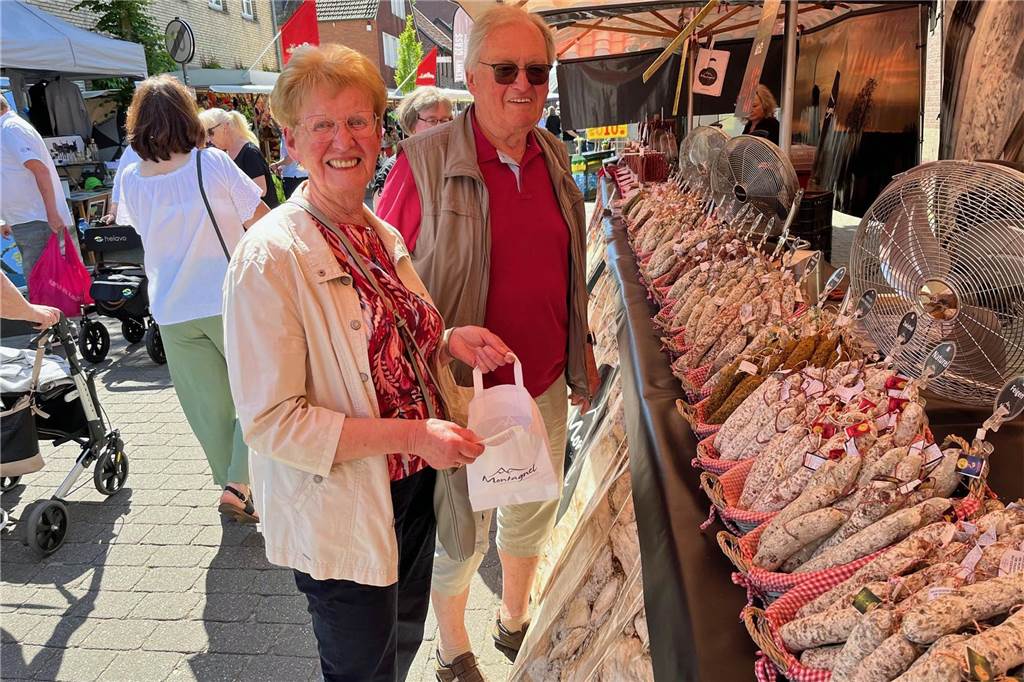 Zwei Menschen stehen vor einem Verkaufsstand mit Wurstwaren