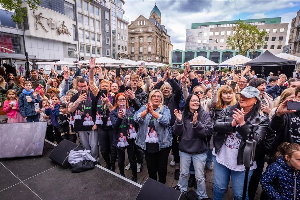 Menschen tanzen vor einer Bühne.