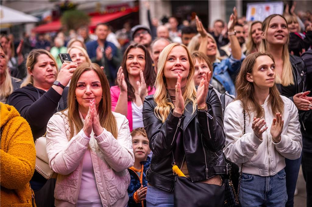 Menschen tanzen vor einer Bühne.