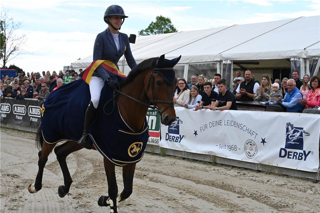 Reiterin reitet mit ihrem Pferd eine Ehrenrunde. 