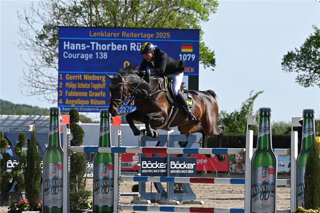 Ein Reiter springt mit einem Pferd über einen Sprung.