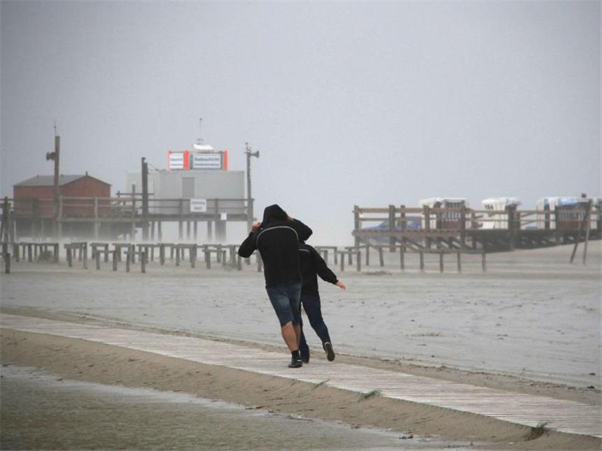 Orkantief wütet über weiten Teilen Deutschlands Spaziergänger stemmen sich am Strand von St. Peter-Ording gegen den ersten Herbststurm des Jahres. Foto: Wolfgang Runge