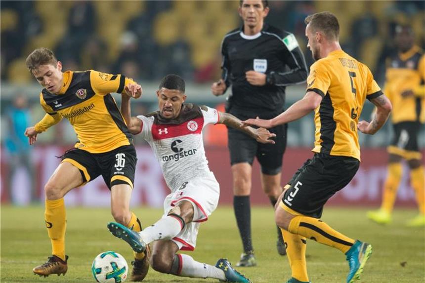 St. Pauli holt einen 3:1-Sieg in Dresden St. Paulis Jeremy Dudziak (M) setzt sich im Kampf um den Ball gegen die Dresdner Niklas Hauptmann (l) und Manuel Konrad (r). Foto: Sebastian Kahnert