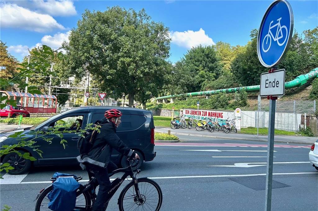Ein Radfahrer fährt an der Kreuzung Weißenburger Straße / Gronaustraße an einem Auto vorbei.