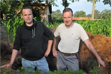 Stefan Heßeling (l.) und Thomas Vöcker grillen nach eine uralten Methode.