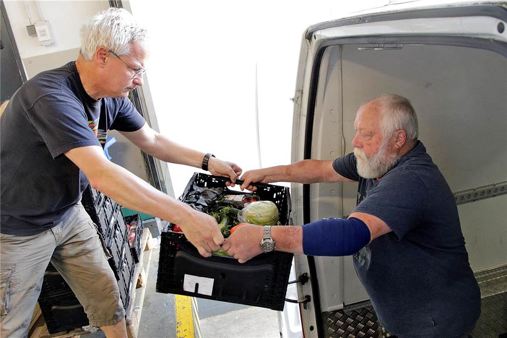 Unterwegs mit den „Glücksbringern“: So kommt die Haltener Tafel an ihre Waren Stefan Winz reicht Hans Petermann die Lebensmittelboxen an.