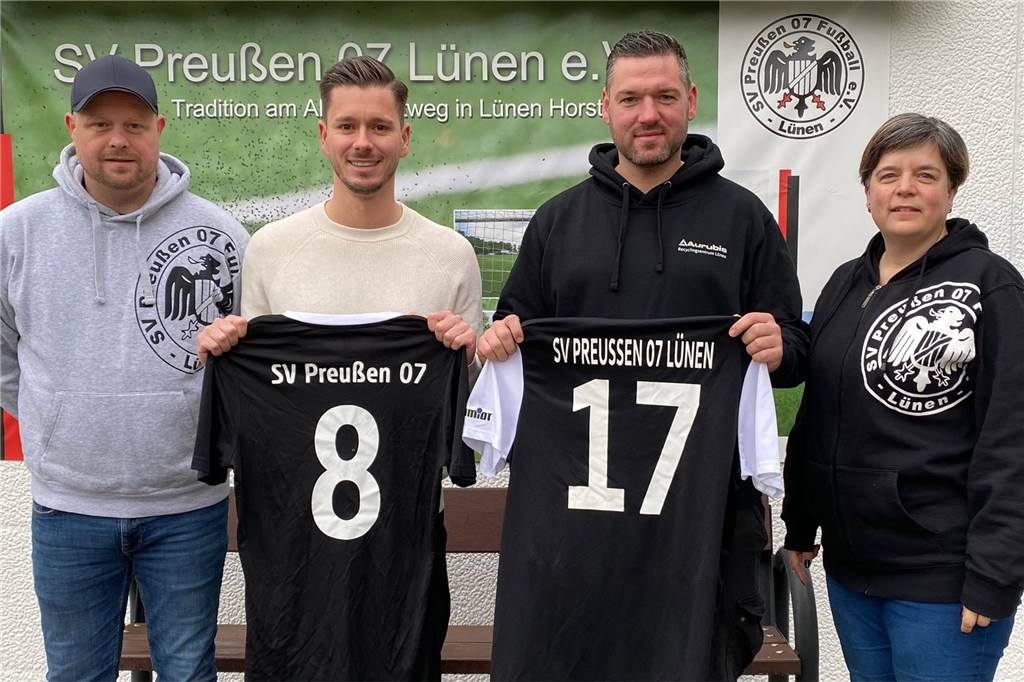 Zwei Spieler halten ein Trikot des SV Preußen in der Hand.