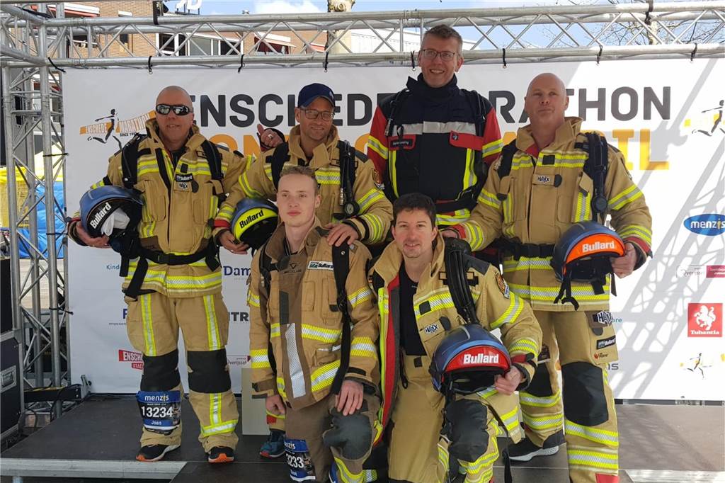 50-Kilometer-Marsch in voller Uniform: Warum Feuerwehrmann Stephan Lendring (52) das macht Stephan Lendring (dunkle Montur) und seine Kameraden vom „Club der blauen Helme“ bei einem karitativen Lauf in Enschede.