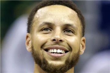 Stephen Curry freut sich über einen Jungen. Foto: Rick Bowmer/AP