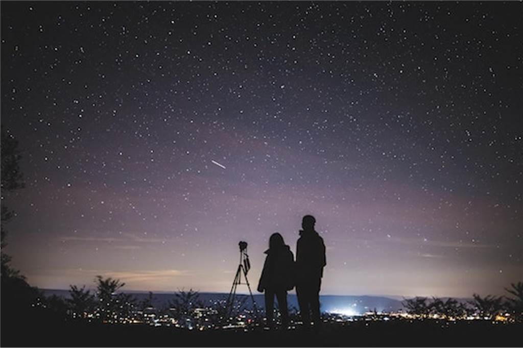Galaktische Ausflüge: 8 Planetarien und Sternwarten in NRW menschen beobachten sterne von einem hügel aus