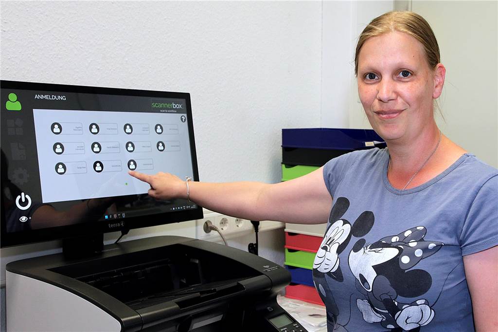 „Wir kommen an unsere Grenzen“: Steuerberater suchen Mitarbeiter Eine Frau steht an einem Dokumentenscanner