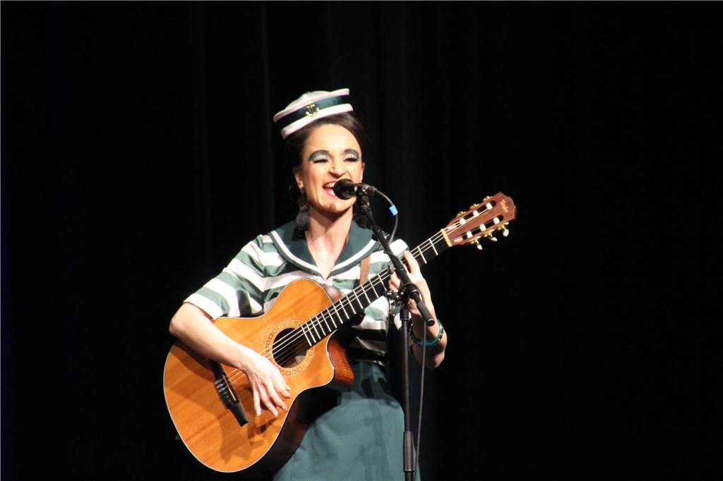Tina Werzinger mit Gitarre auf der Bühne.