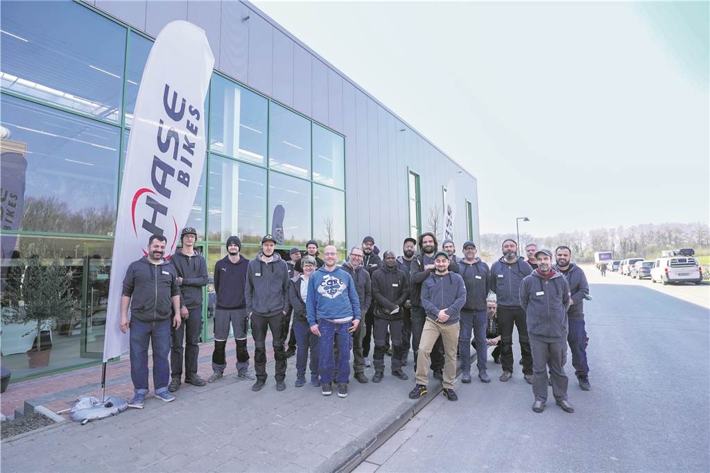 Stolz stehen diese Mitarbeiter vor der neuen Halle 4 von Hase-Bikes. Sie sind ein Team und verantwortlich für die Montage der Räder.