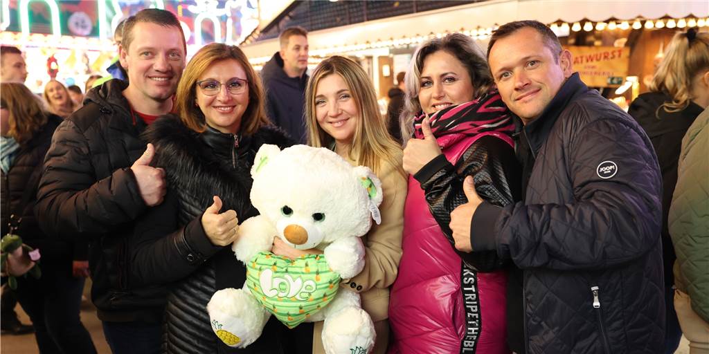 Besucher auf der Sim-Jü-Kirmes in Werne halten einen Teddybär.