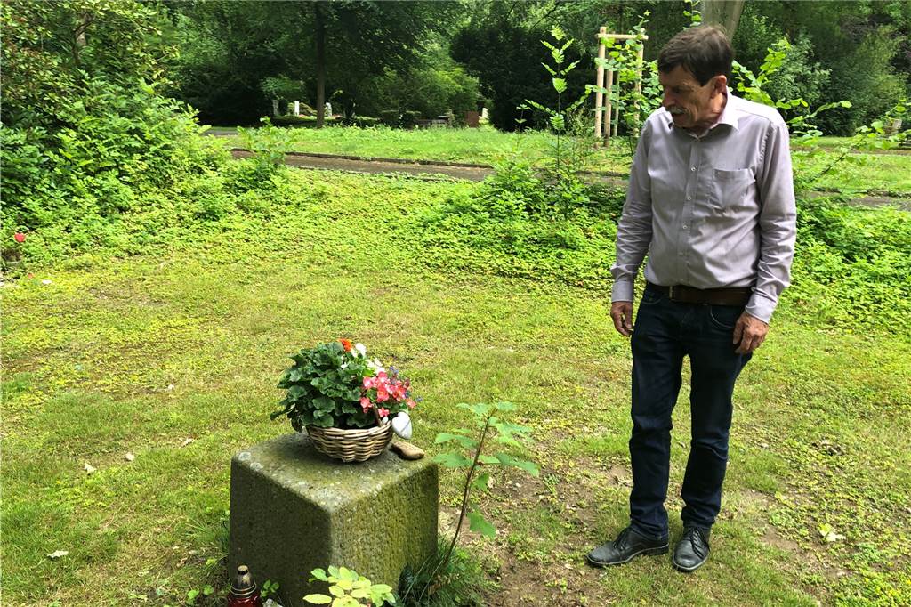 Martin Struck hat seit zehn Jahren seinen eigenen Sarg im Büro stehen Struck auf dem Hauptfriedhof vor einer Trauerstätte, die jemand auf dem anonymen Grabfeld angelegt hat.
