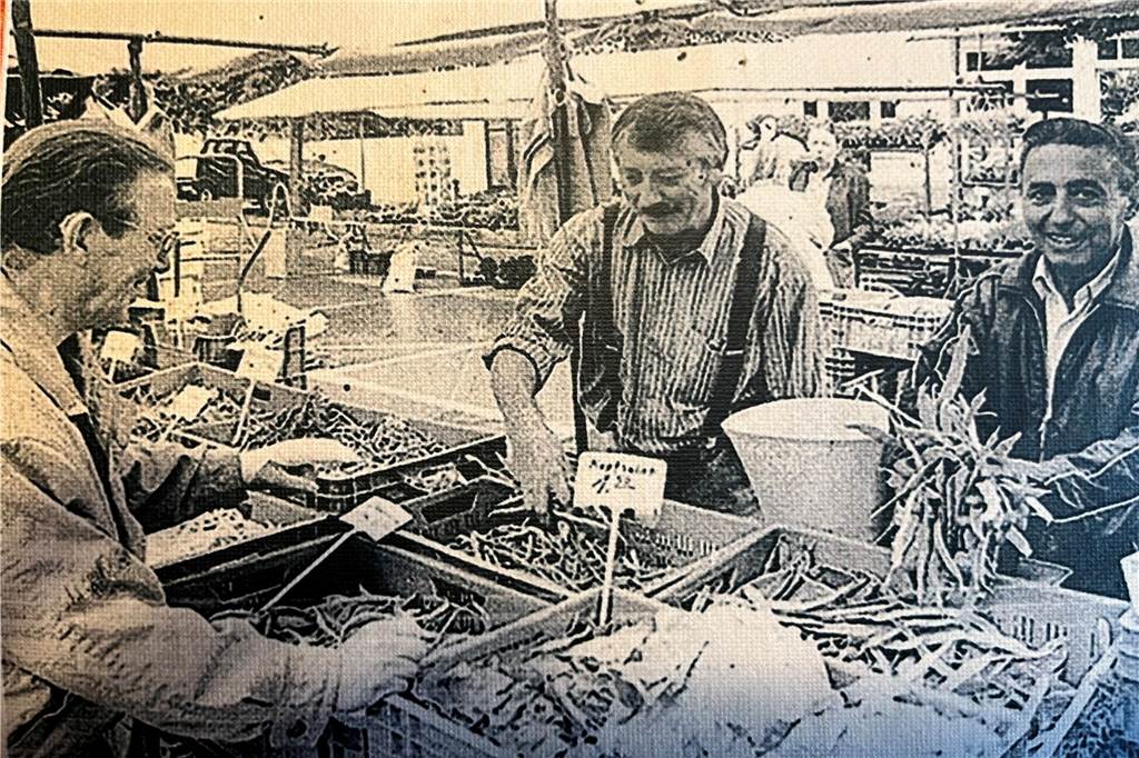 Urgestein des Wochenmarkts: Sturmhart Schinkel war von Anfang an dabei Schwarz-Weiss-Foto von einem Verkaufsstand auf einem Markt.