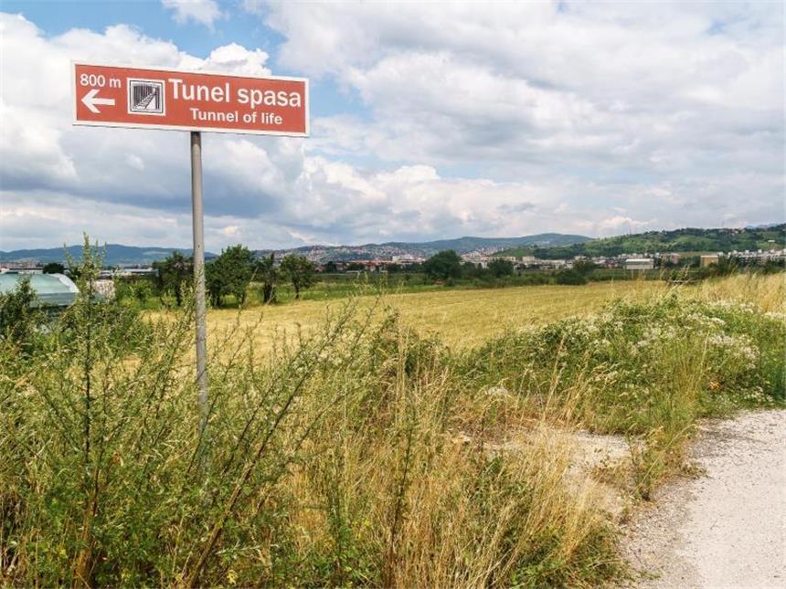 Erinnerung an den Krieg: Sarajevos "Tunnel des Lebens" Südlich des Flughafens von Sarajevo spaziert der Besucher durch Vorort-Idylle. Ein Schild weist den Weg zum Tunnel-Museum. Foto: Philipp Laage/dpa-tmn