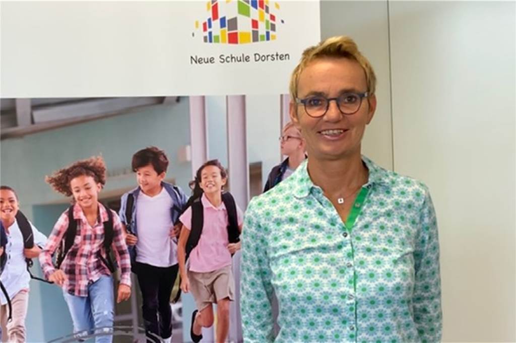Diese Folgen könnten zu teure Klassenfahrten an den Schulen haben Susanne Bender vor einem Plakat der Neuen Schule Dorsten.