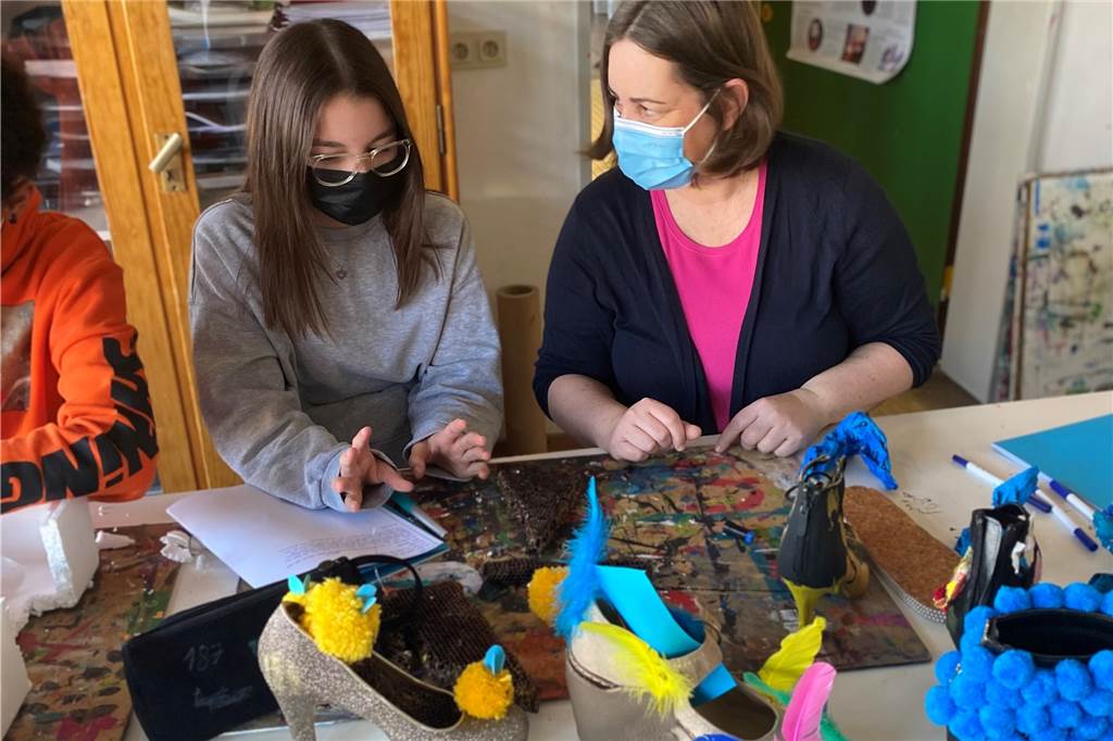 Lehrerin aus Dorsten ist Deutschlands vorbildlichste Schulleiterin Susanne Schulte an einem Tisch mit Kunstwerken und einer Schülerin