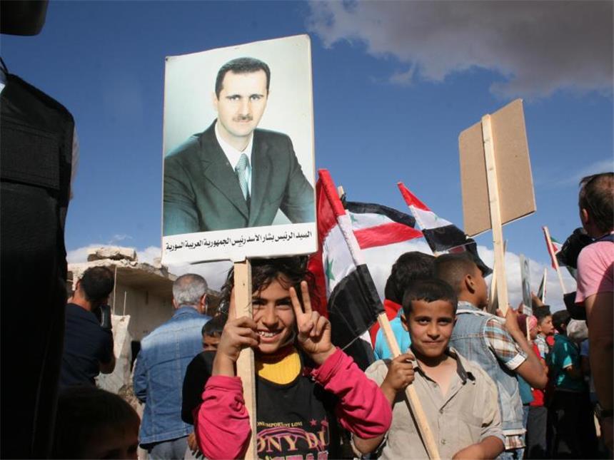 Assads neues Parlament eröffnet Syrische Kinder mit einem Porträt von Syriens Machthaber Baschar al-Assad. Foto: Friedemann Kohler/Archiv