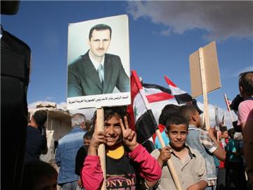 Syrische Kinder mit einem Porträt von Syriens Machthaber Baschar al-Assad. Foto: Friedemann Kohler/Archiv