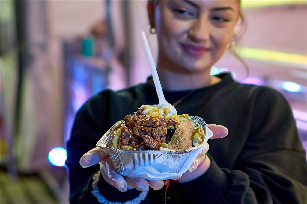 Talia Oktay serviert Kumpir, hier mit einem Topping unter anderem aus Fleisch und Mais.