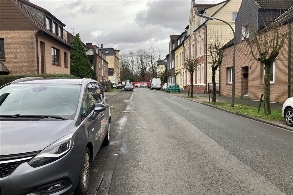 Eine Straße in Recklinghausen. An den Seiten stehen Autos und Wohnhäuser.