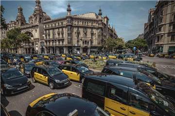 Taxifahrer blockieren eine Kreuzung in Barcelona. Foto: Matthias Oesterle/ZUMA Wire