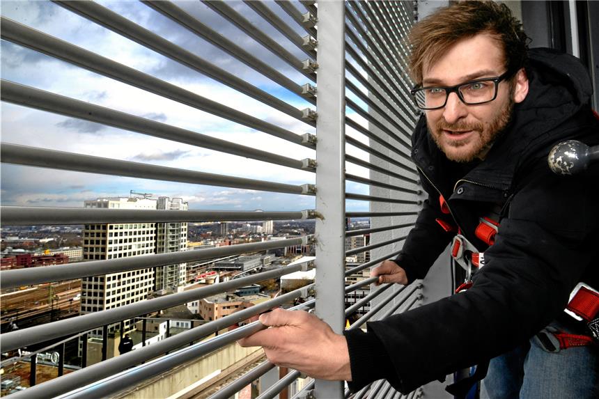 Die Fliegenden Bilder des U-Turms sind müde Techniker Gerrit Hecht tauscht hier auf der Innenseite eines der Fliegenden-Bilder-Fenster auf dem Dach des U-Turms eine kaputte Leuchtlamelle gegen eine reparierte aus.