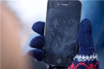 Technikfrust durch Frost: Wer nicht will, dass sein Smartphone so endet wie dieses unglückliche iPhone, sollte es warm halten und Temperaturschwankungen vermeiden. Foto: Karolin Krämer/dpa-tmn