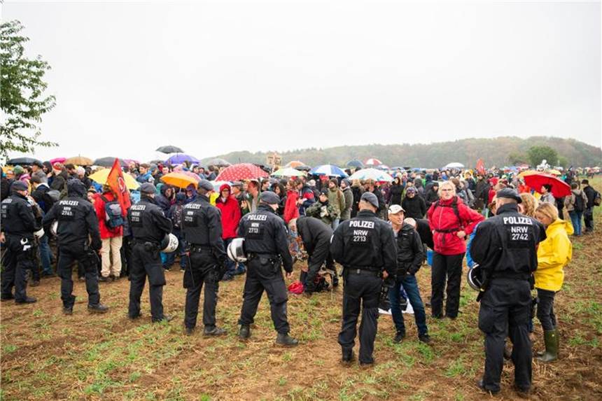 Tausende bei neuen Protesten am Hambacher Forst Teilnehmer der Demonstration gegen die Rodung des Hambacher Forsts warten im Regen vor einer Polizeikette. Foto: Christophe Gateau