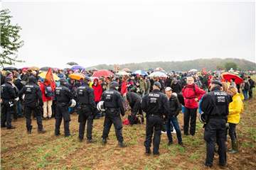 Teilnehmer der Demonstration gegen die Rodung des Hambacher Forsts warten im Regen vor einer Polizeikette. Foto: Christophe Gateau