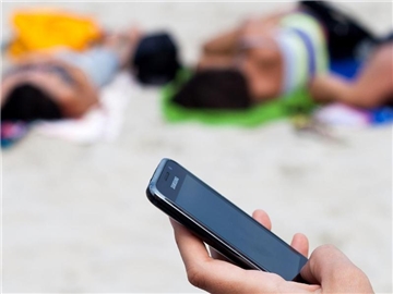 Telefonieren am Strand wird günstiger: Die Zusatzkosten für Handynutzer im EU-Ausland werden wie geplant im Juni 2017 abgeschafft. Foto: Daniel Naupold