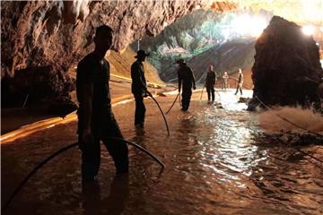 Thailändische Soldaten saugen mithilfe von Schläuchen Wasser aus der teilweise überfluteten Höhle. Foto: Royal Thai Navy