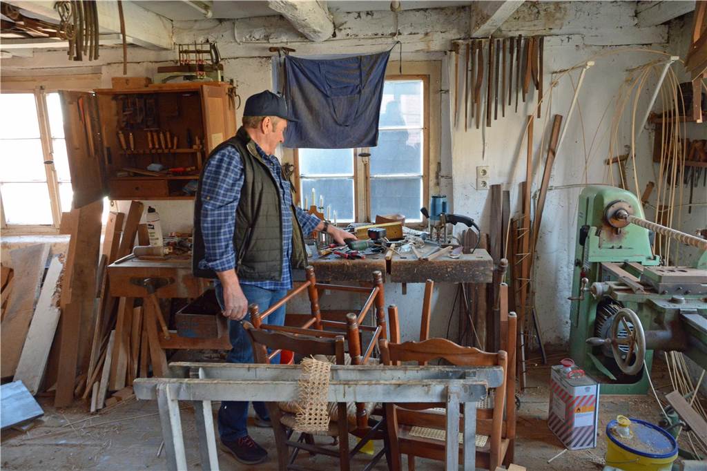 Theo Elberfeld - der Cousin von Heinz - in der Stuhlmacherwerkstatt. Die Werkstatt sieht aus, als habe Heinz sie gestern erst verlassen. Im Erdgeschoss befindet sich der Lagerraum für Rohmaterialien. Über eine schmale Holztreppe gelangt man in den Arbeitsraum.