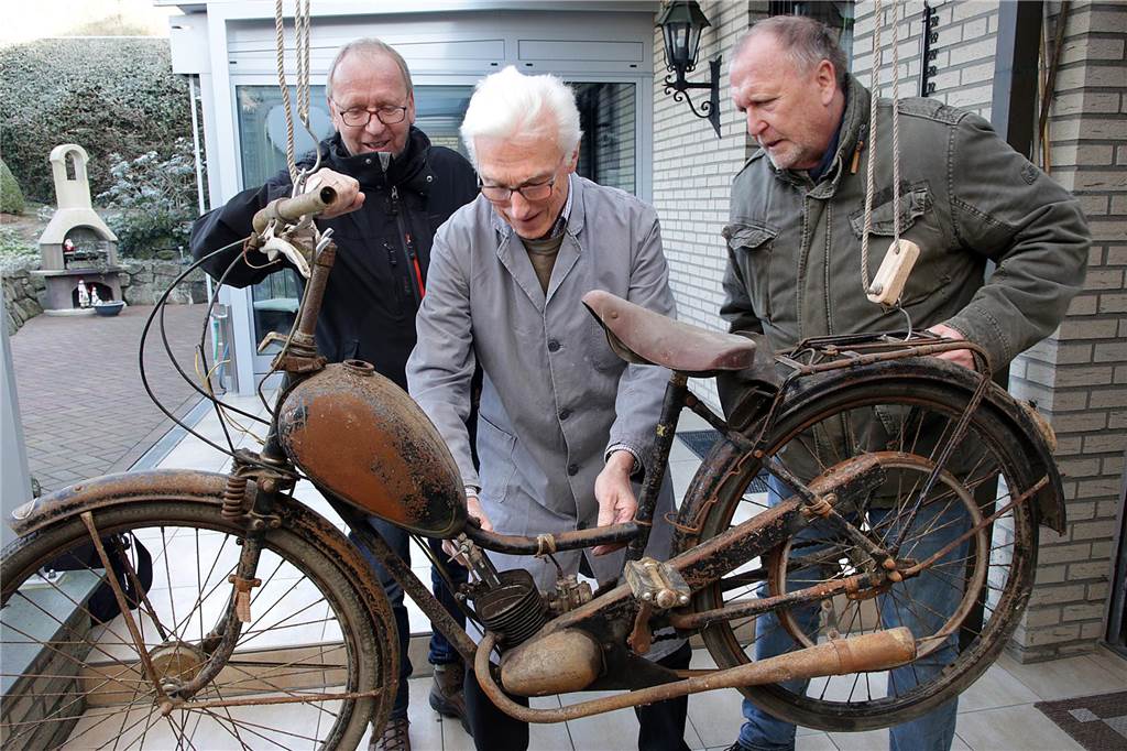 Theo Schmitz hatte im Januar mit der Restaurierung des historische Mopeds begonnen, das Norbert (l.) und Wolfgang Giese gefunden haben.