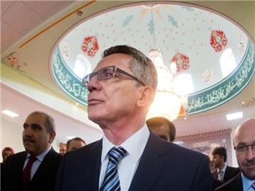 Thomas de Maizière (M) besucht eine Moschee im niedersächsischen Ronnenberg. Der Bundesinnenminister hat sich in der Diskussion um einen muslimischen Feiertag zu Wort gemeldet. Foto: Julian Stratenschulte/Archiv