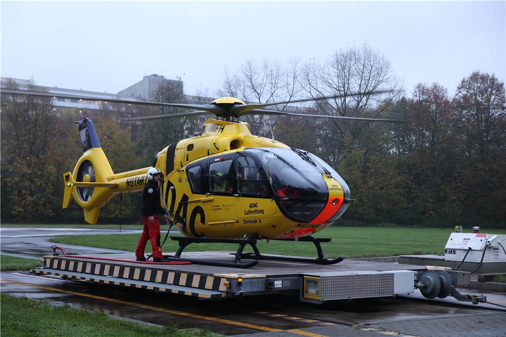 Gelber Hubschrauber steht auf einer Plattform draußen.